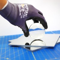 The acrylic first surface mirror is stacked with a glass sphere on top to create an optical illusion. Acrylic First Surface Mirror Stacked with Sphere